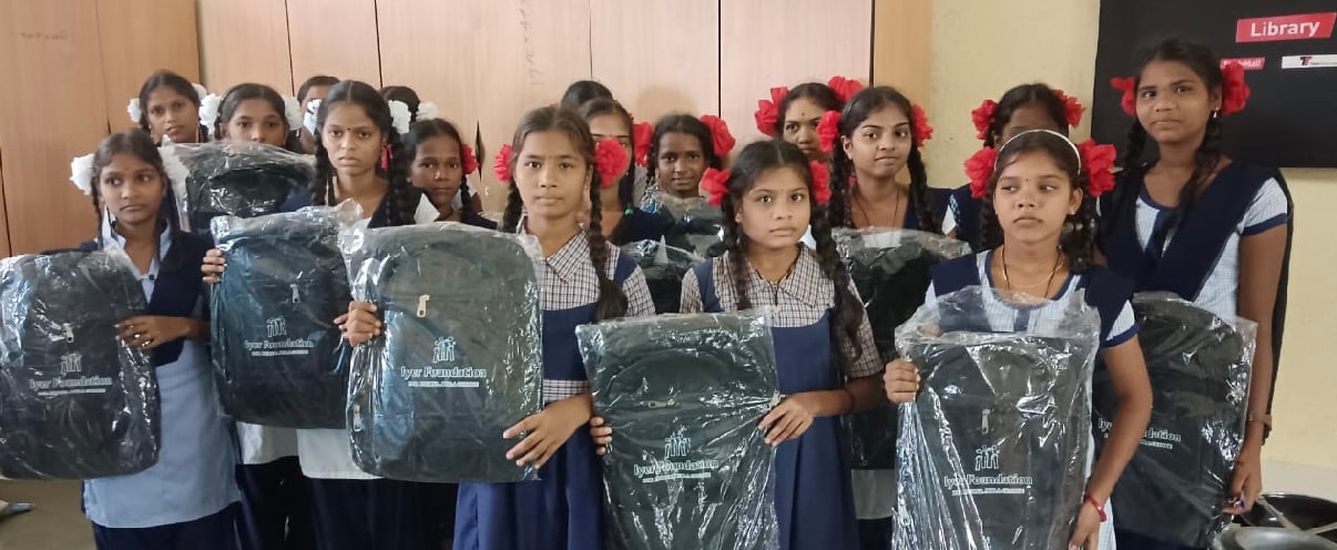 Girls holding Iyer Foundation school bags